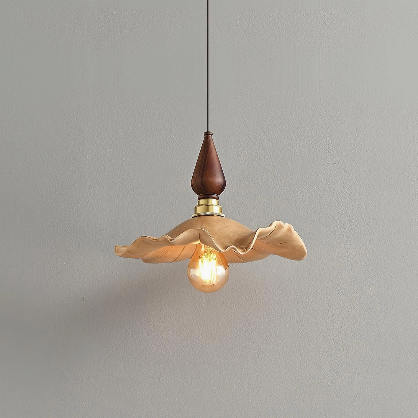 Wavely organic pendant light featuring rippled resin shade with brass hardware and warm wood finial, three-quarter angle