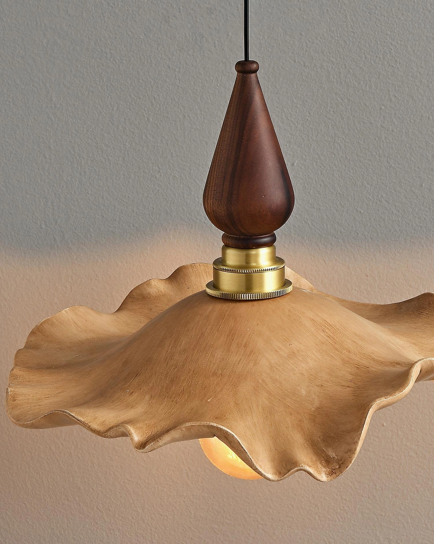 Wavely organic resin pendant light with sculptural wave-pattern shade and walnut wood finial, studio portrait