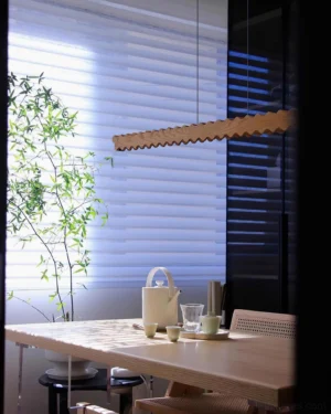 Wavira wooden linear chandelier installed above dining table Japanese interior ambient lighting