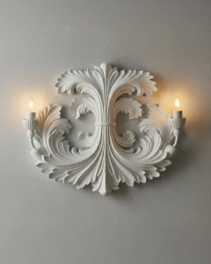 Neoclassical carved wall sconce illuminated with warm candlelight highlighting detailed acanthus leaf carving