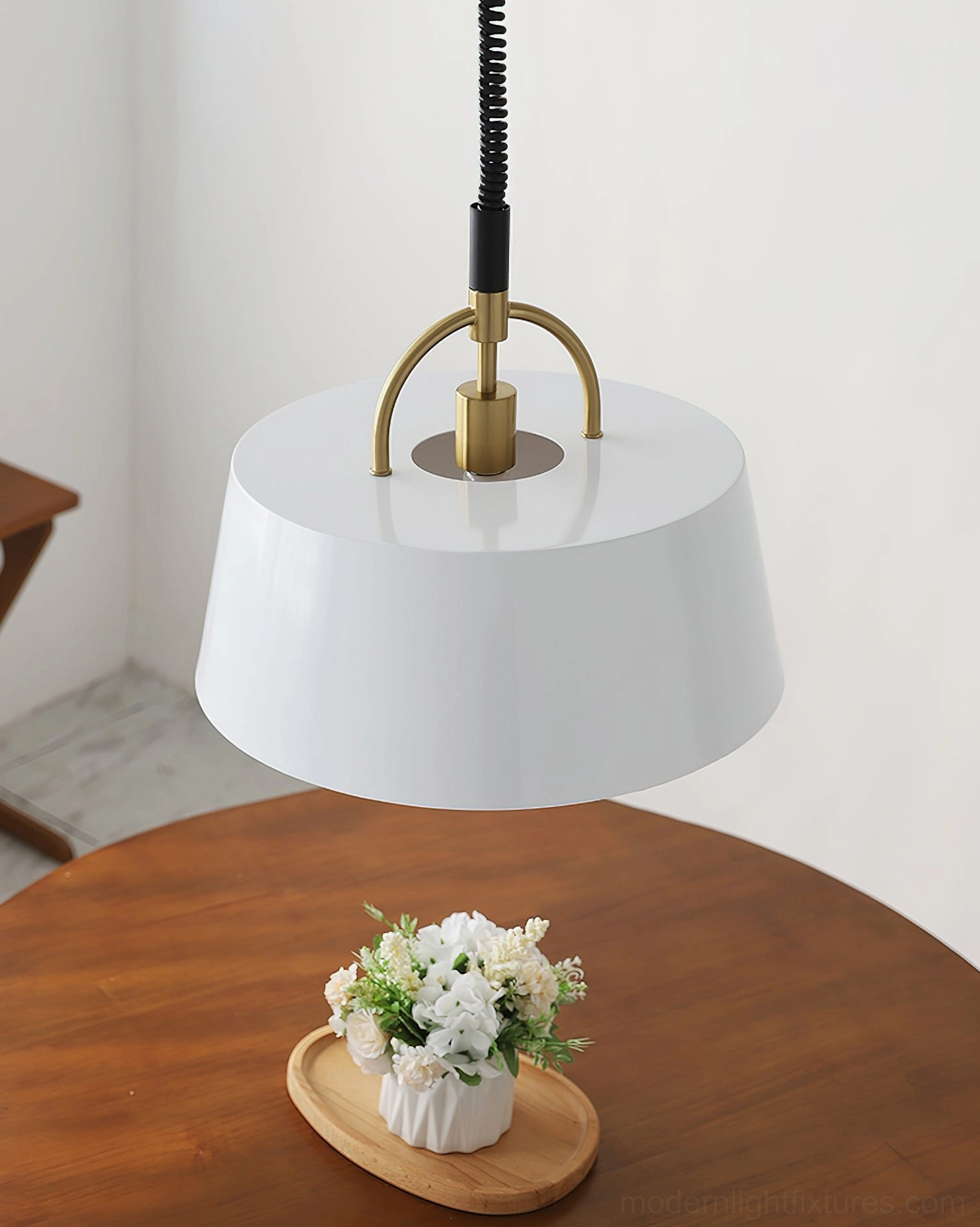 White Angelo tapered pendant light with matte finish and brass accent hardware on wooden surface