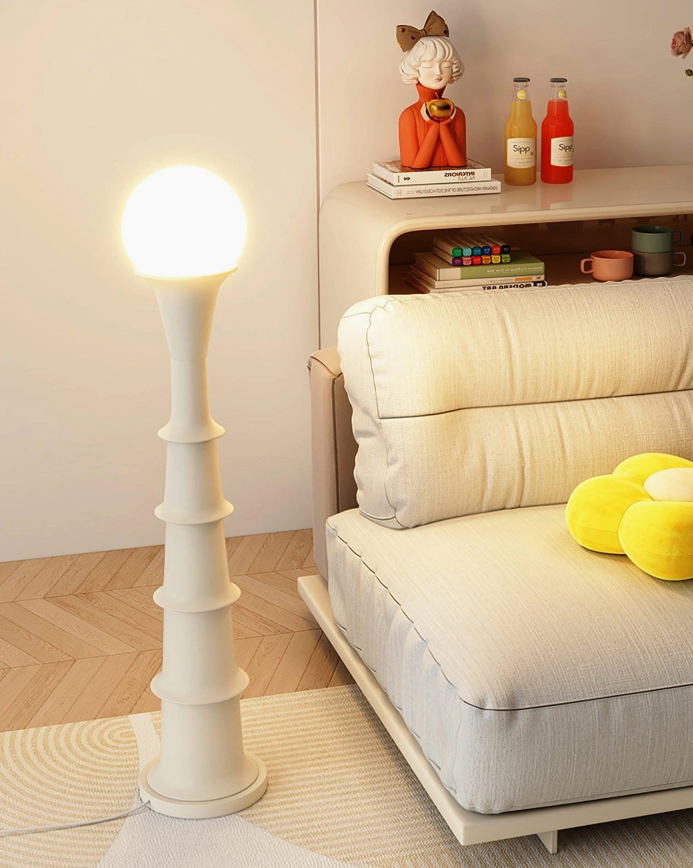 White off-white bamboo joint floor lamp front three-quarter view with tiered column form, lounge sofa pairing