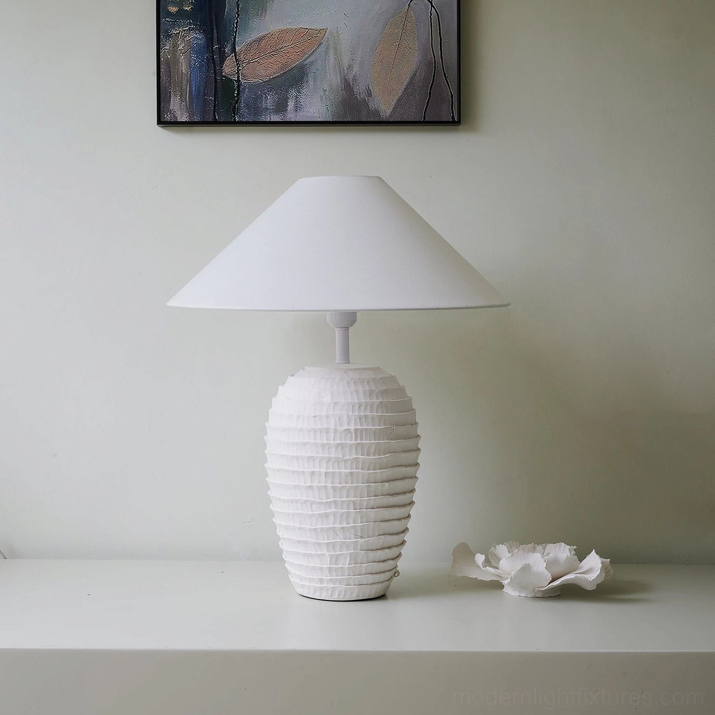 Minimalist white ceramic ribbed table lamp with matching ceramic flower decor in styled interior scene