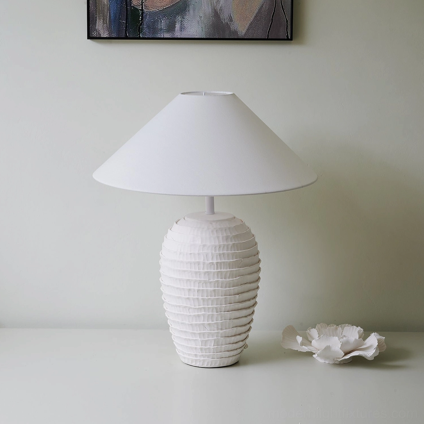 Modern white ceramic table lamp styled in minimalist interior with ceramic flower decor and wall art