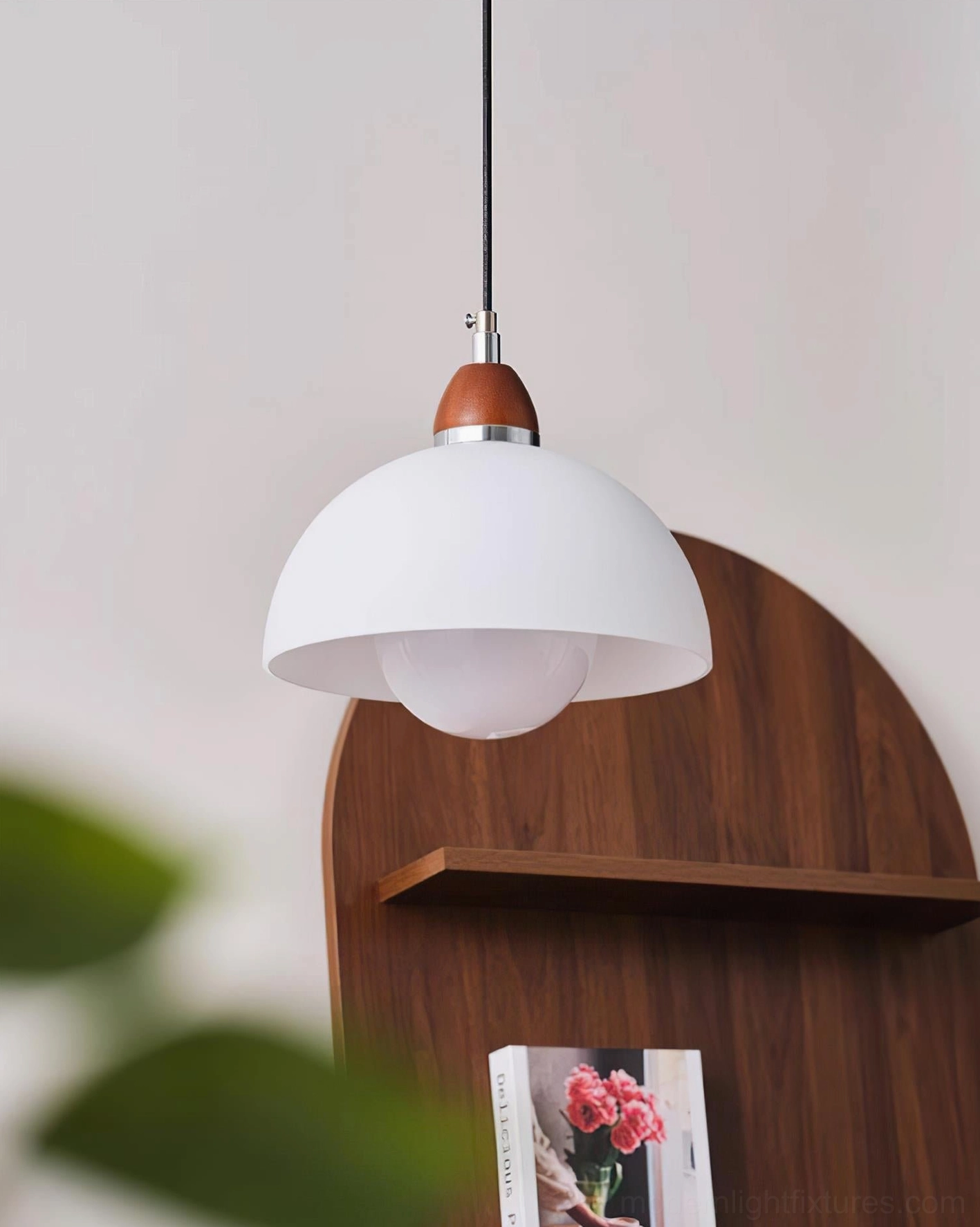 White domed pendant light close-up, matte shade with brown wooden top fixture against wooden shelf background