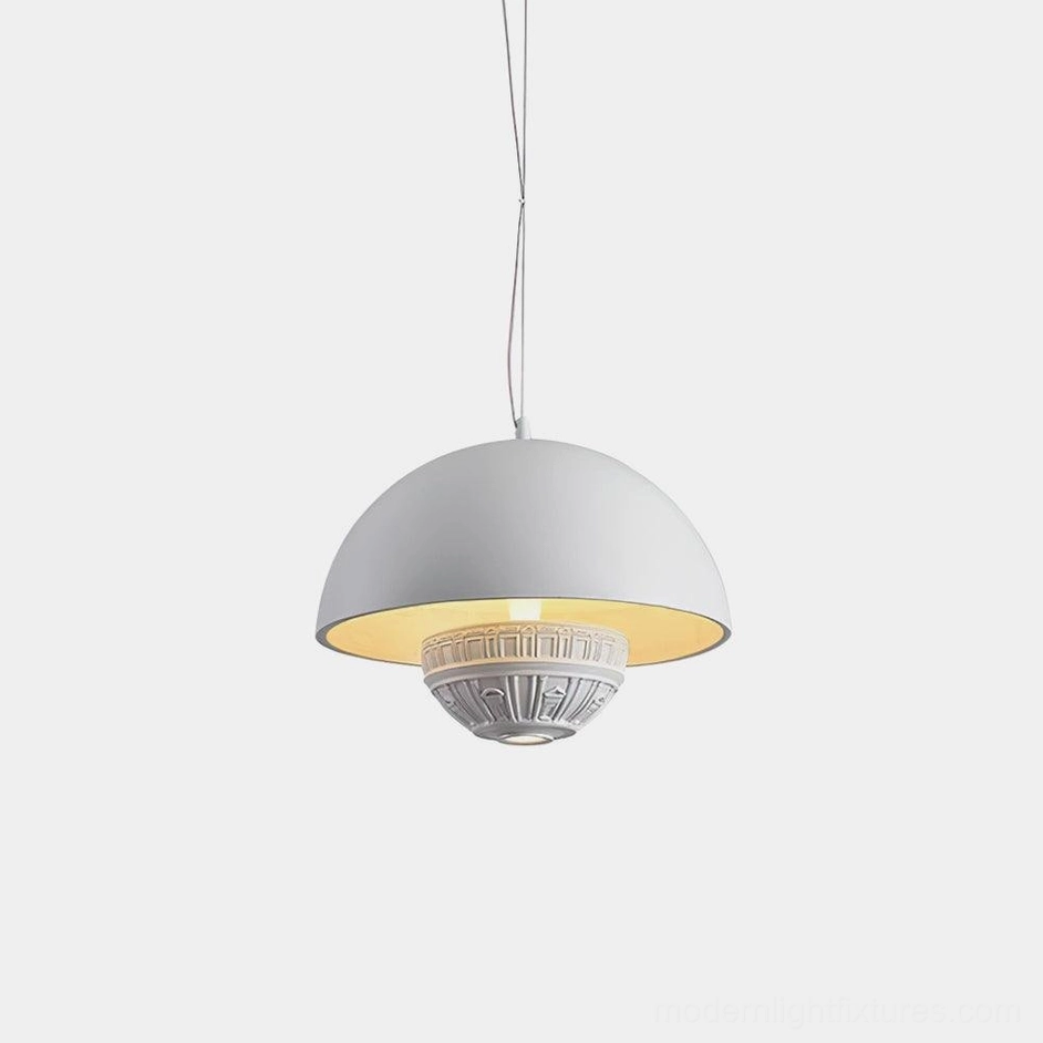 White dome pendant light with carved decorative base and warm golden interior close-up view