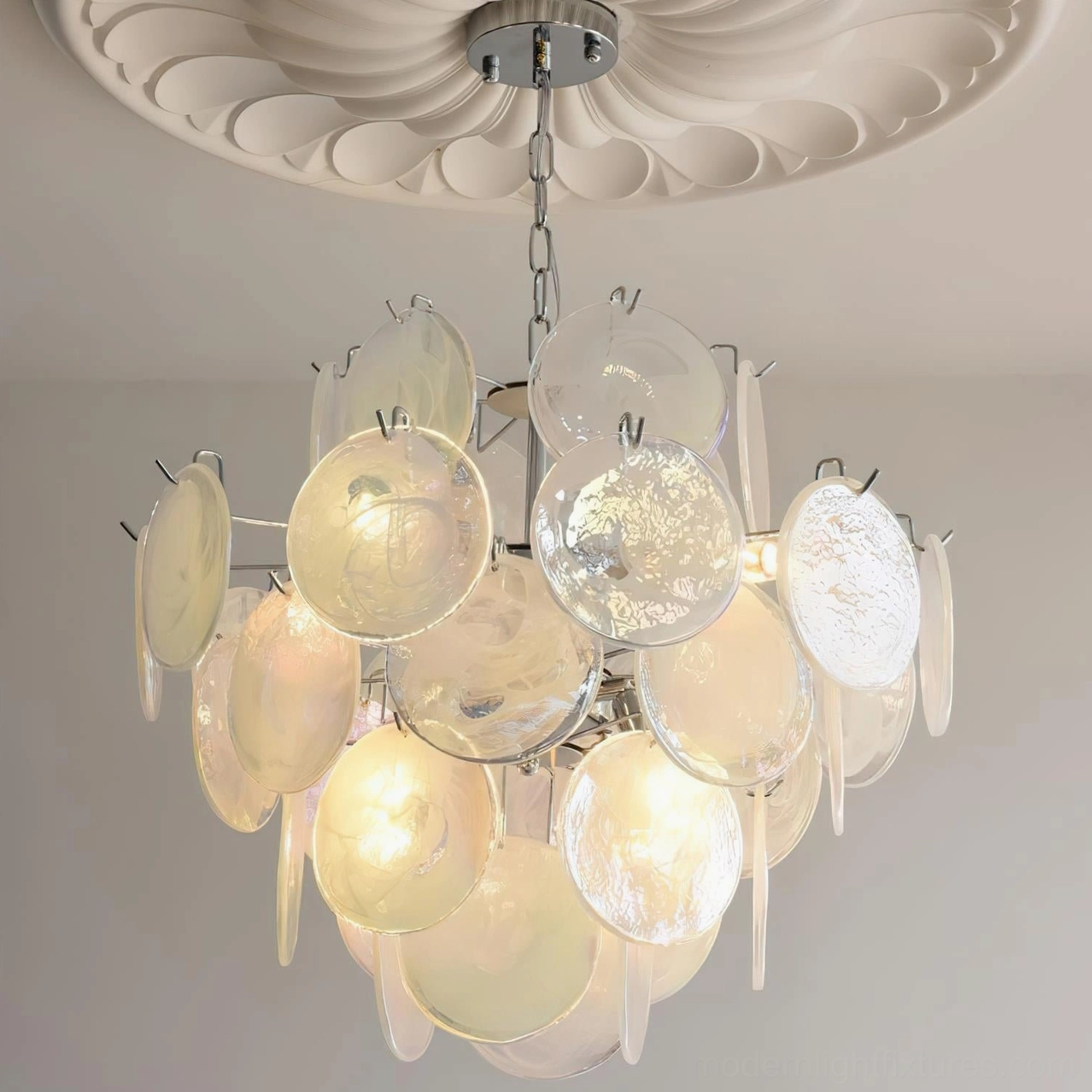 White cream glass disc chandelier ceiling-mounted with illuminated warm bulbs, chrome frame detail visible