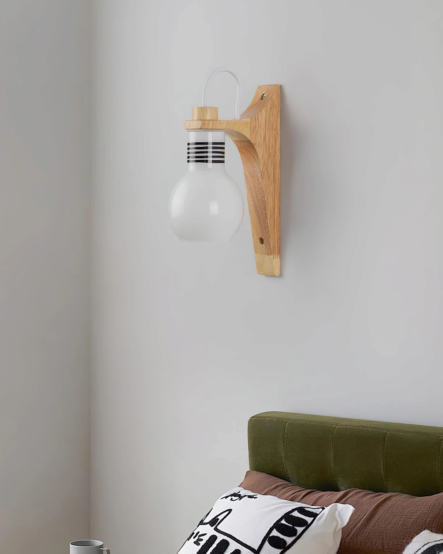 White globe wall sconce, minimal wood design, green upholstered headboard bedroom setting