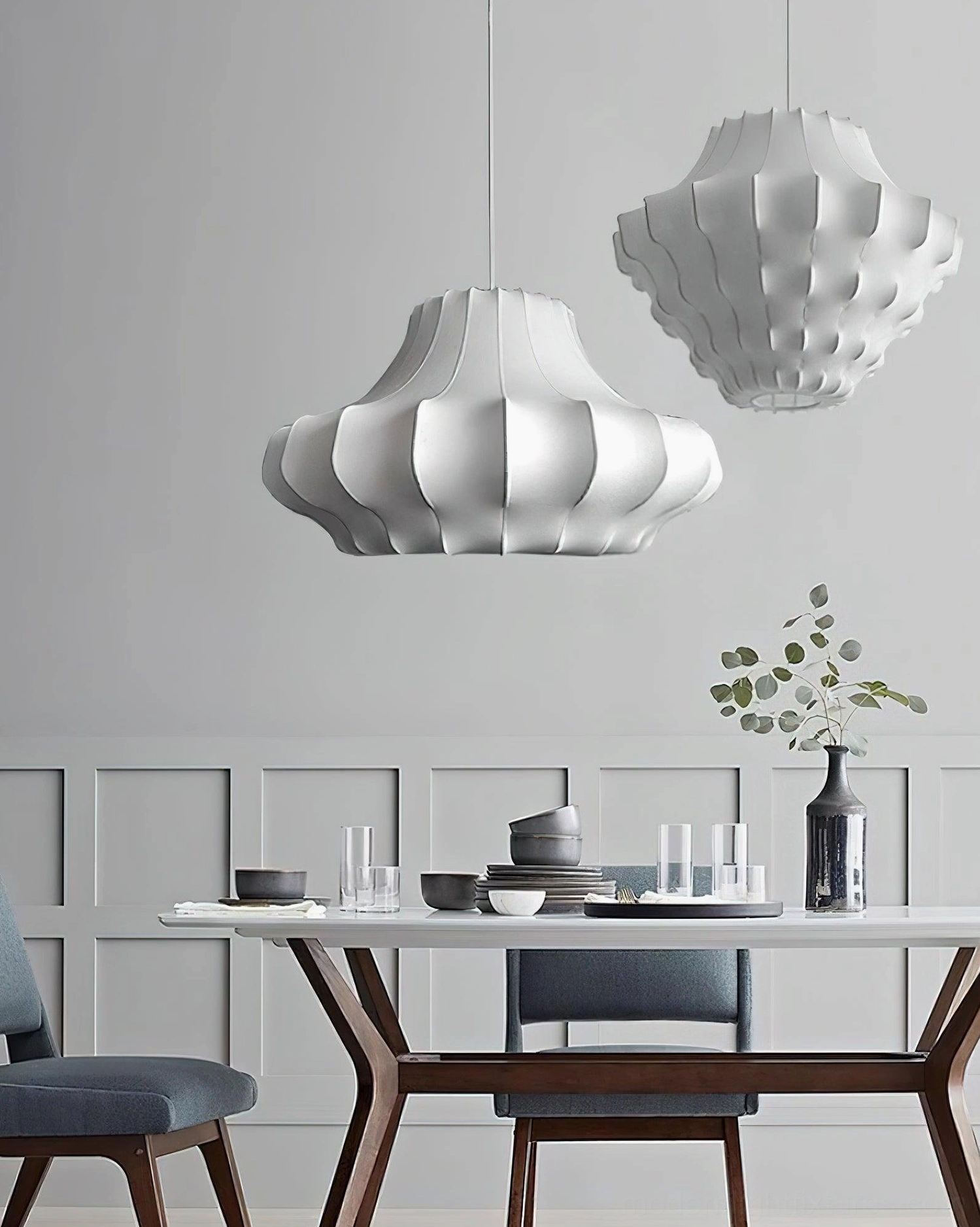 Two pure white matte Nordic sculptural pendant lamps in modern wooden dining room