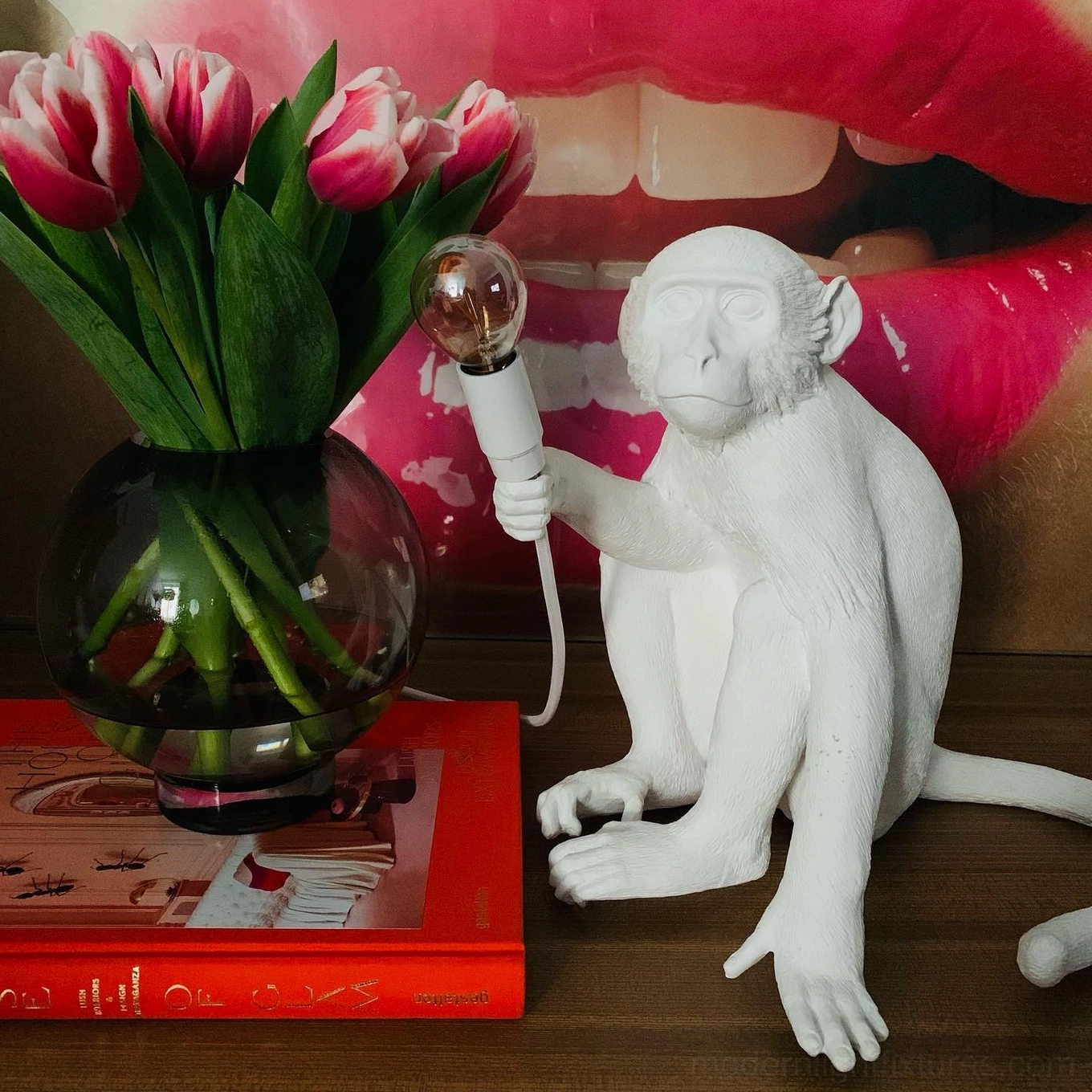 White monkey table lamp three-quarter front view on bedroom vanity desk with tulip flowers