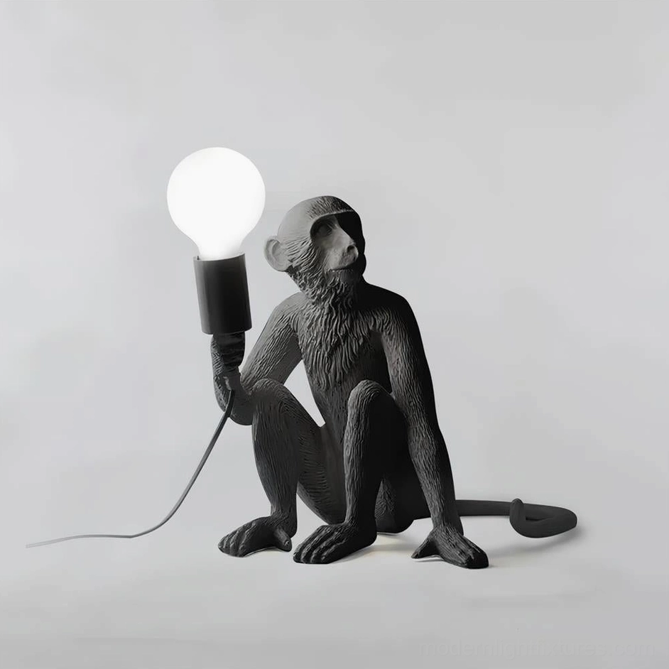 White matte resin monkey table lamp in sitting pose with exposed bulb, front flat studio view