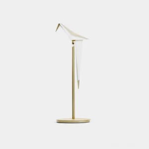 Origami crane table lamp with white folded shade and brass base on plain white background studio view