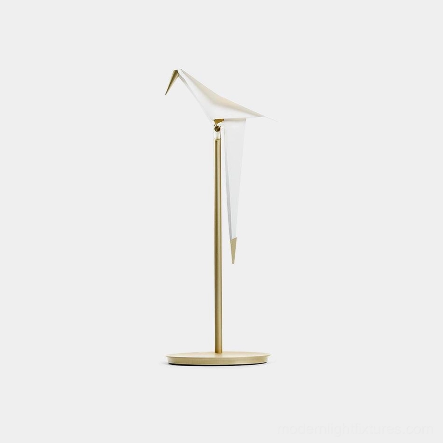 Origami crane table lamp with white folded shade and brass base on plain white background studio view
