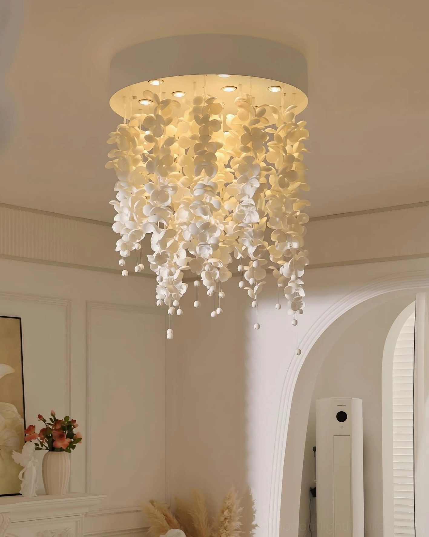 White ceramic pendant chandelier suspended in neutral cream residential interior with natural warm home decor coordination