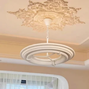 Modern white ring chandelier installed in French-style room with ornate ceiling medallion