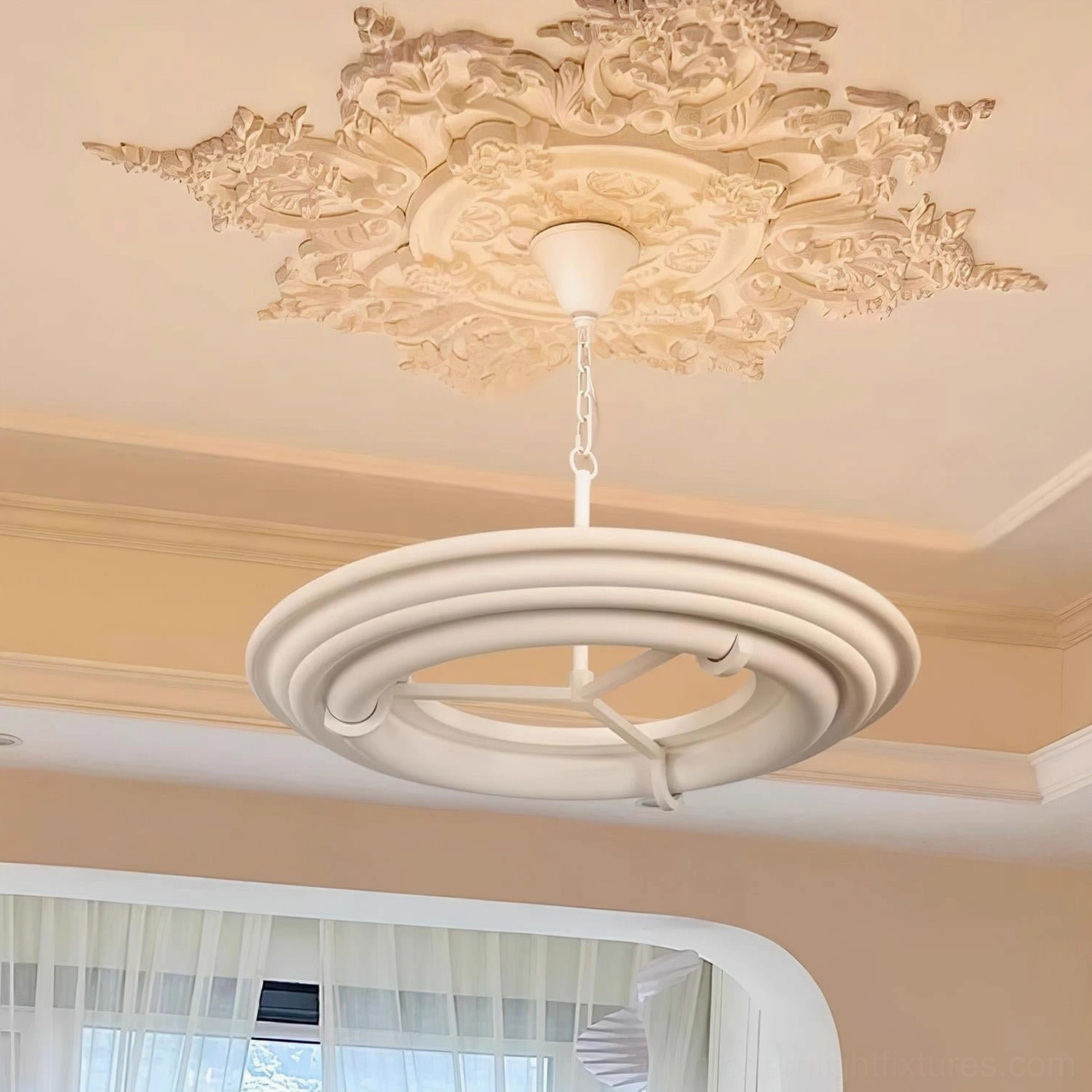 Modern white ring chandelier installed in French-style room with ornate ceiling medallion