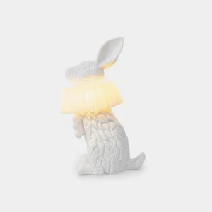 Modern white rabbit resin table lamp with pleated shade, rear left perspective view showing detailed fur texture and ruffled collar design