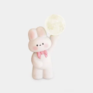 Cute white rabbit table lamp with pink bow tie on studio background - integrated LED moon lamp for modern home decor