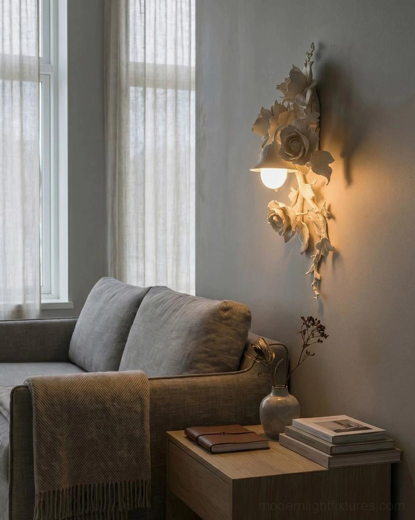 Off-white resin Elysia Bloom floral wall sconce in living room with gray sofa, soft matte botanical relief finish