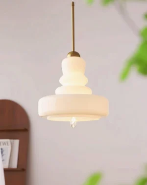 Cream white tiered pendant light fixture overhead view in minimalist interior with wooden shelving