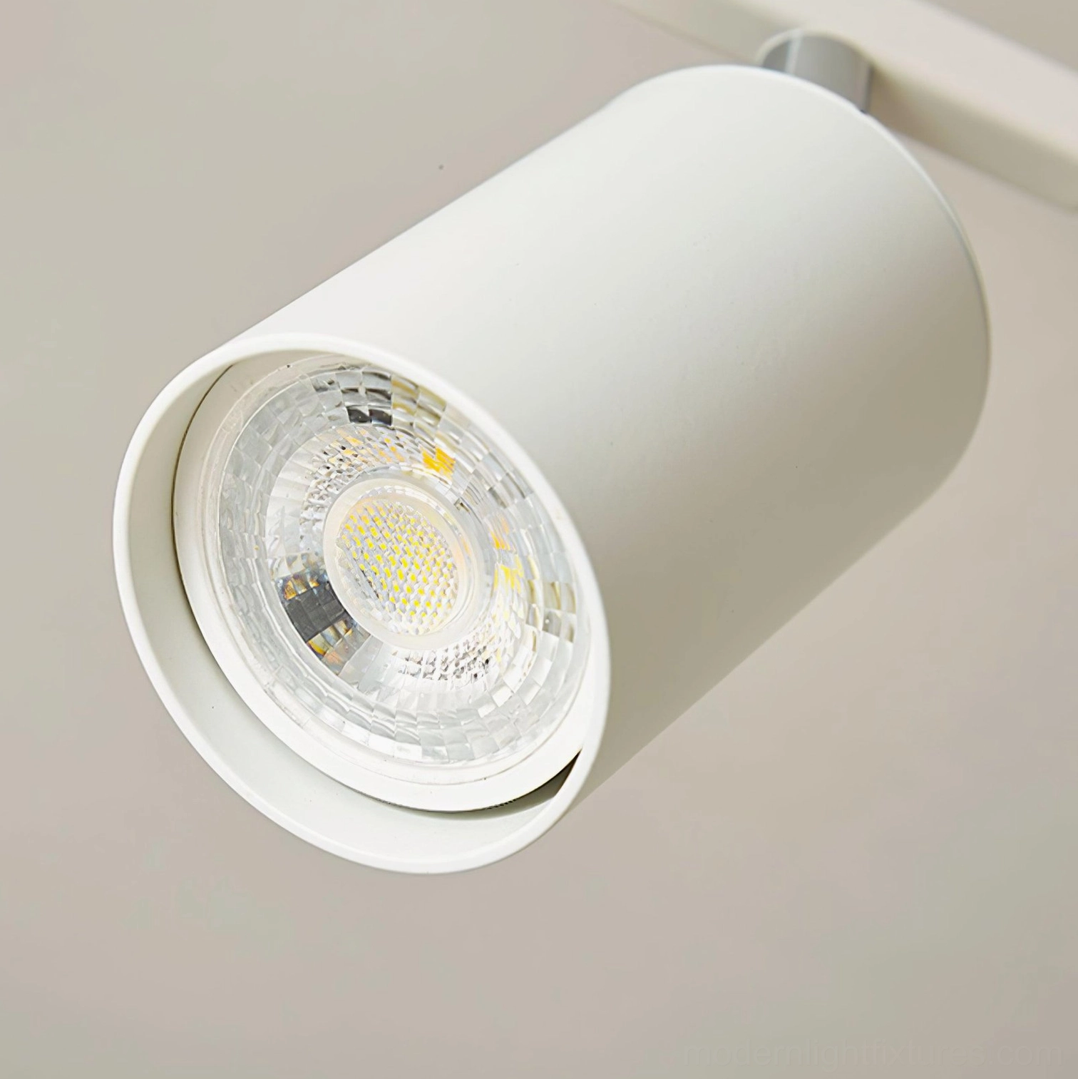 Modern white cylindrical spotlight head close-up, showing internal COB LED reflector design and GU10 socket
