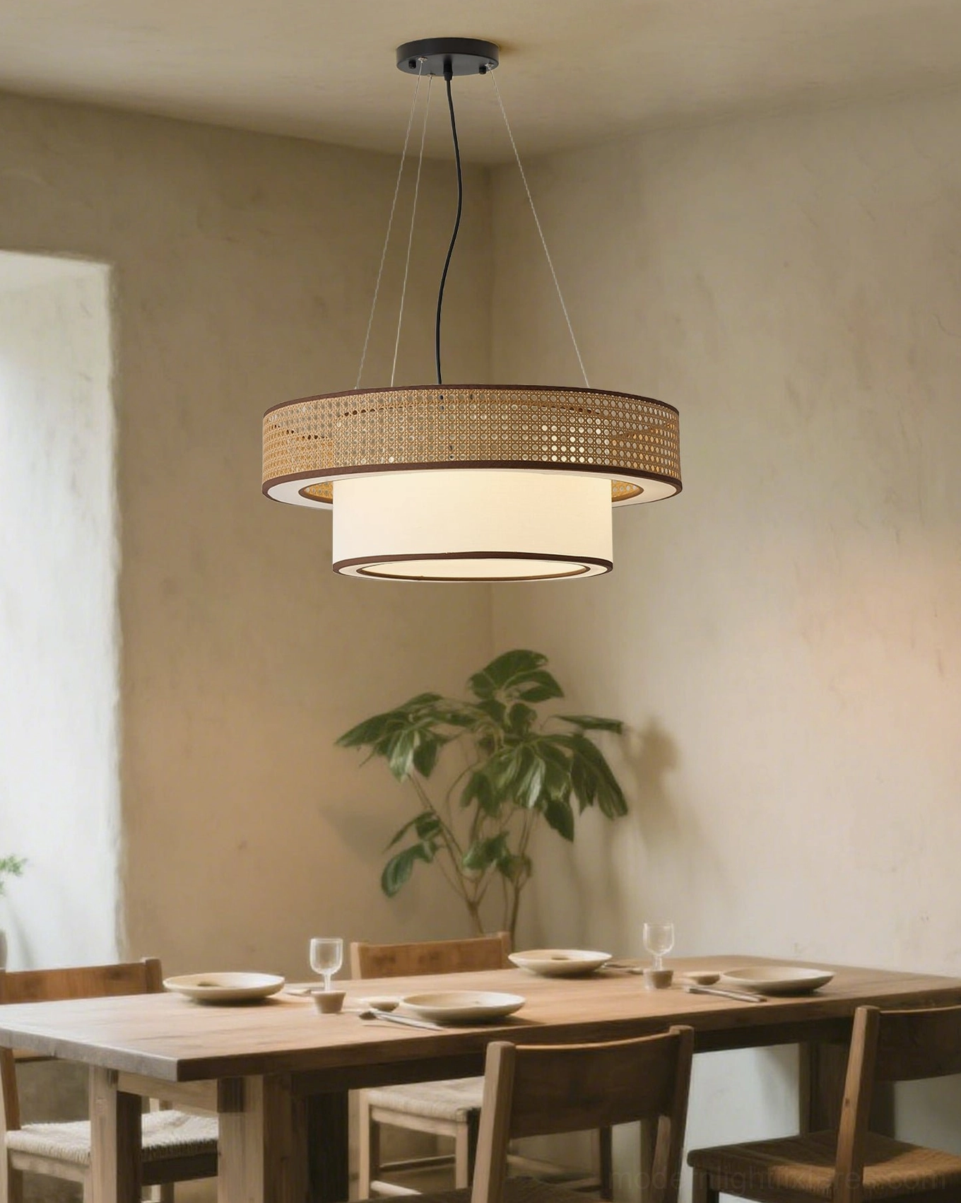 Woven rattan pendant chandelier hanging in farmhouse style dining room above wooden table with floral arrangement, showcasing rustic boho ambiance