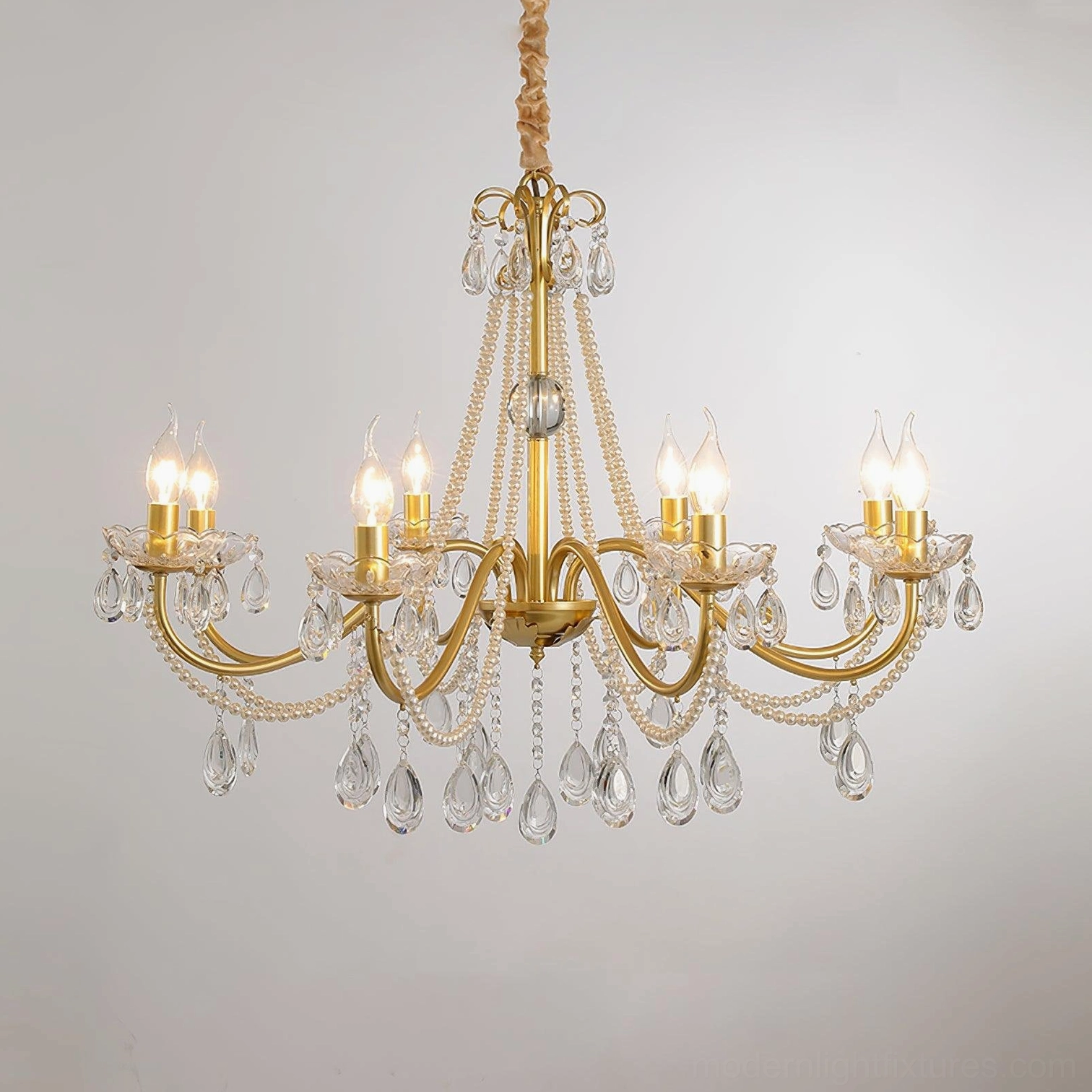 Dual-candle crystal chandelier with gold brass frame, teardrop crystals and decorative glass element, front angle view