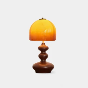 Willow amber glass table lamp with sculpted walnut wood base, studio front view, caramel dome shade
