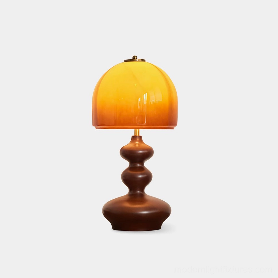 Willow amber glass table lamp with sculpted walnut wood base, studio front view, caramel dome shade