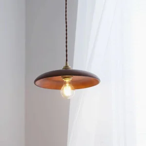 Minimalist wood pendant lighting fixture installed in Japanese-style home interior with sheer curtains and warm vintage bulb glow