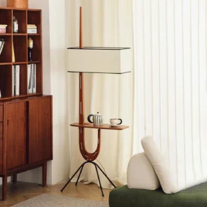 Wood floor lamp with side table shelf displayed in contemporary living room with wooden bookshelf