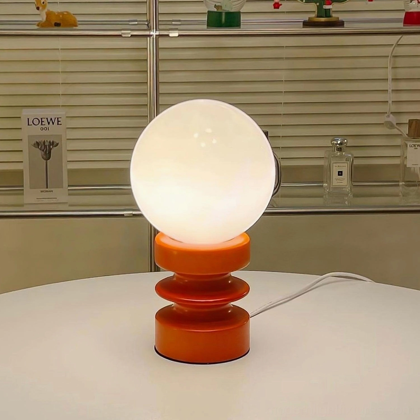 Close-up detail of frosted glass shade and power cord on modern wood base table lamp