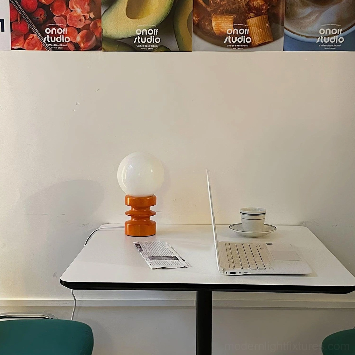 Accordion wood table lamp unlit on home office workspace with laptop and coffee