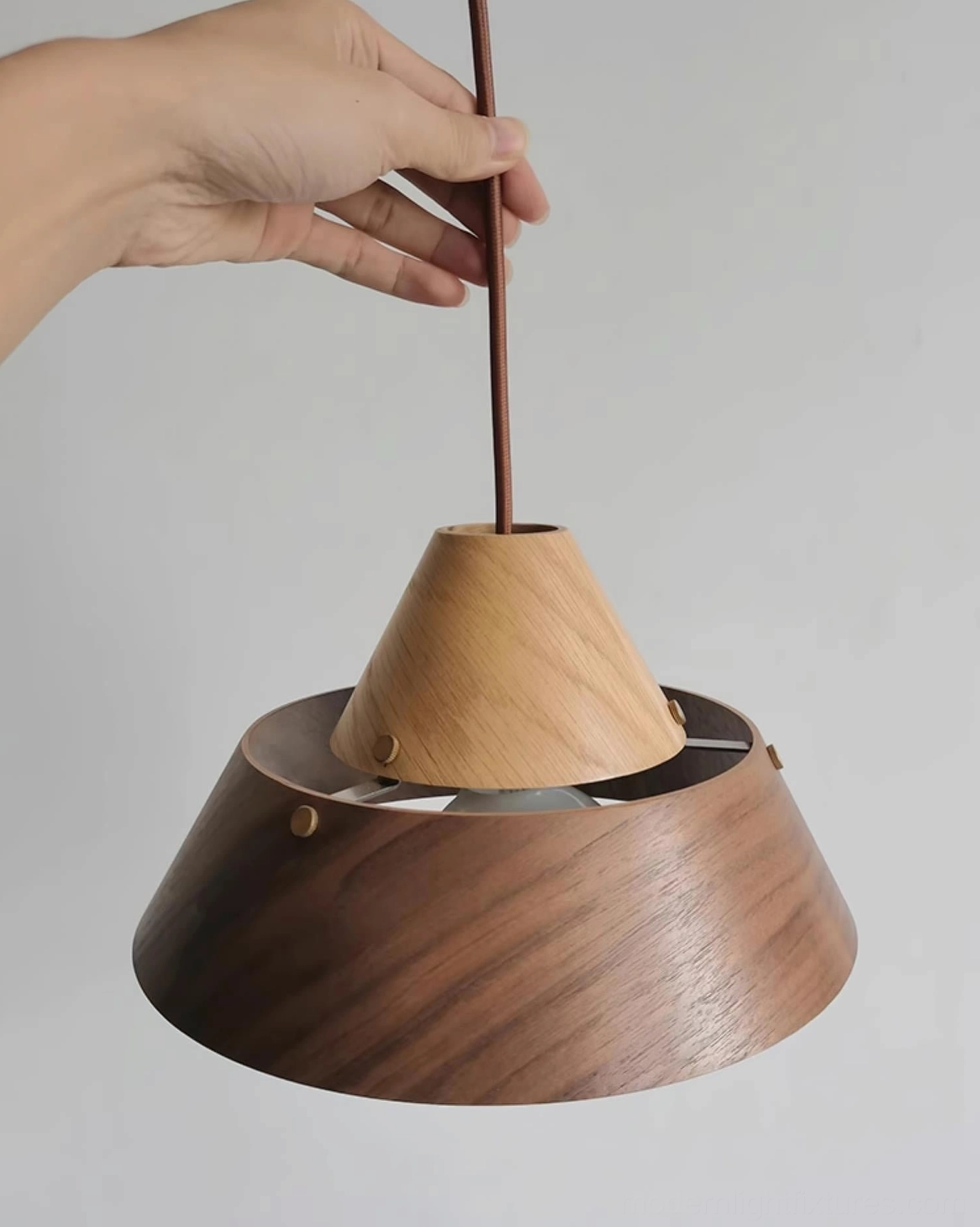 Bottom view of modern wood pendant light showing layered shade construction and brass fasteners