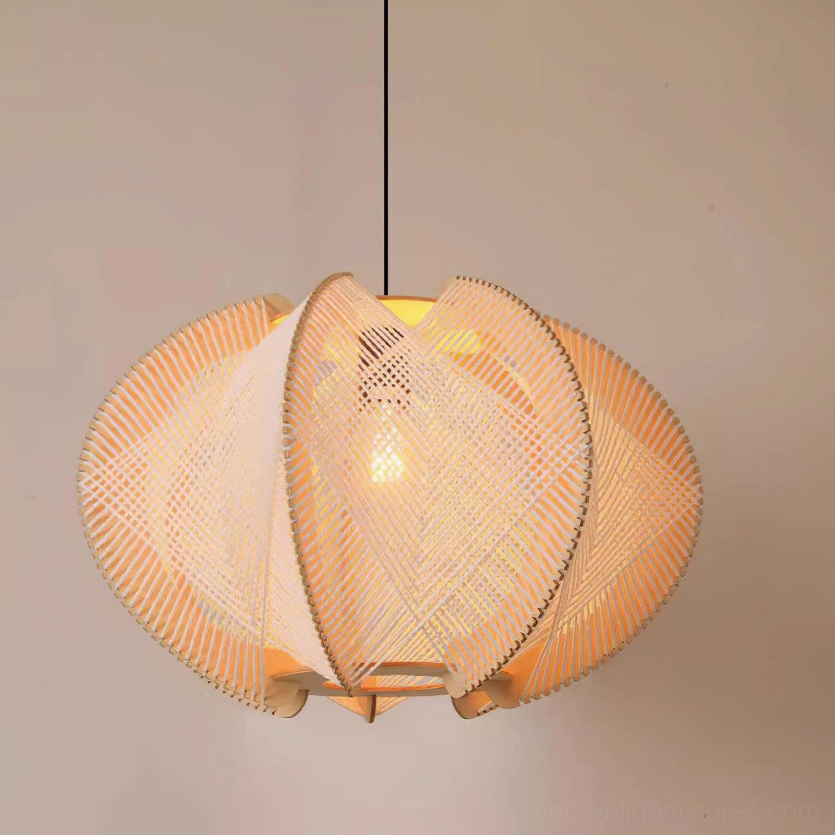 Illuminated woven wood pendant light glowing warm amber light against wall background