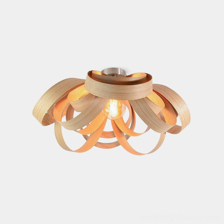 Handcrafted wooden petal ceiling light with natural wood finish in studio view