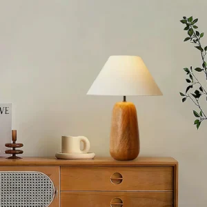 Wooden table lamp on bedroom dresser with warm ambient lighting in cozy boho home interior design setting