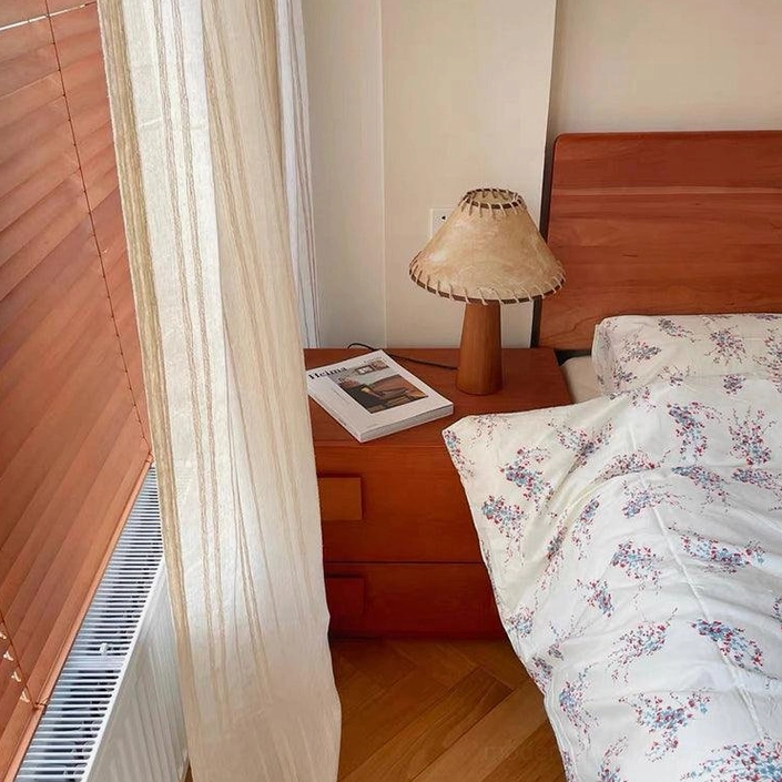 Wood base table lamp with jute shade positioned on reading nook table for focused task lighting and ambiance