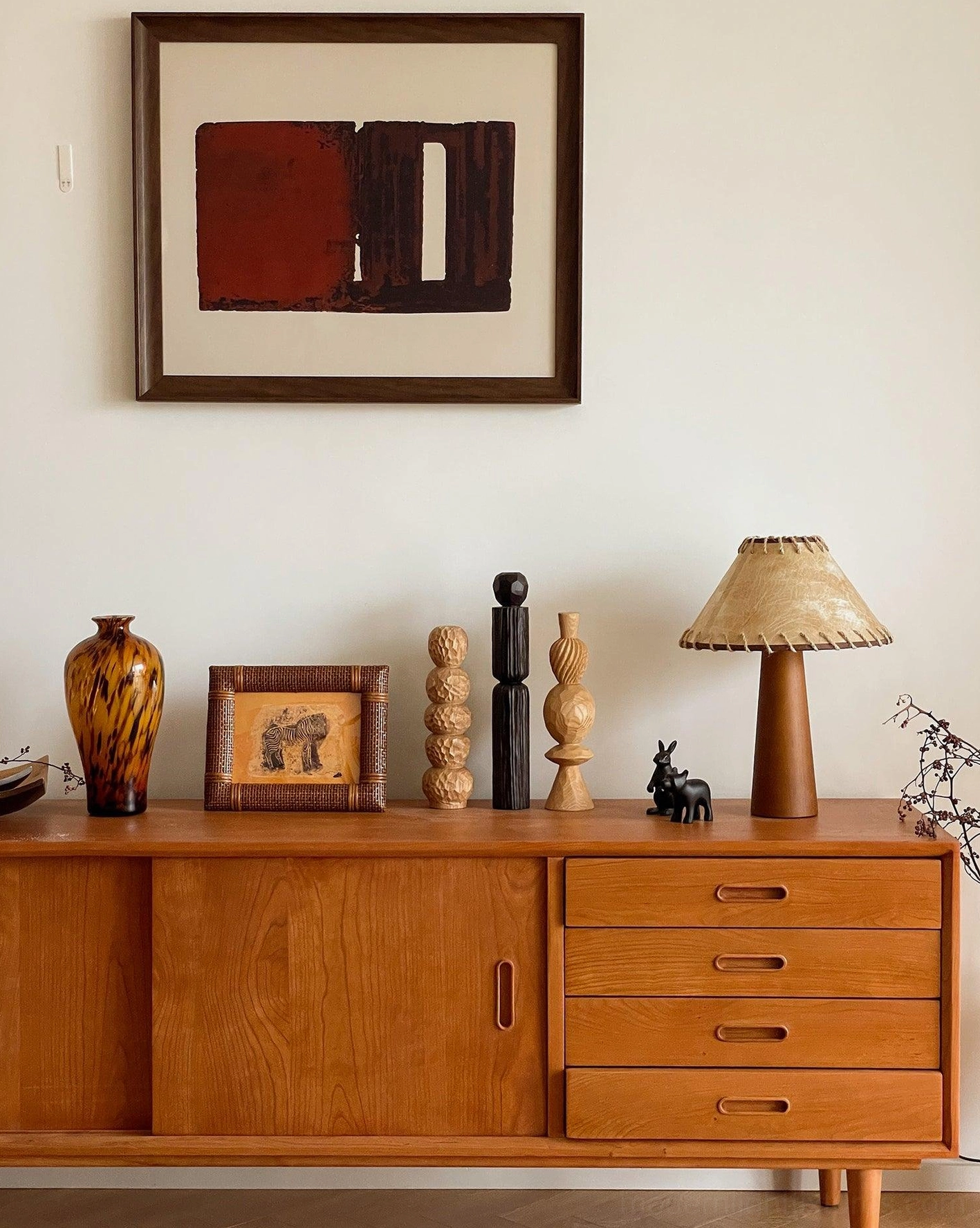 Unlit wood table lamp displayed on vintage wooden sideboard with wall art and decorative home ornaments