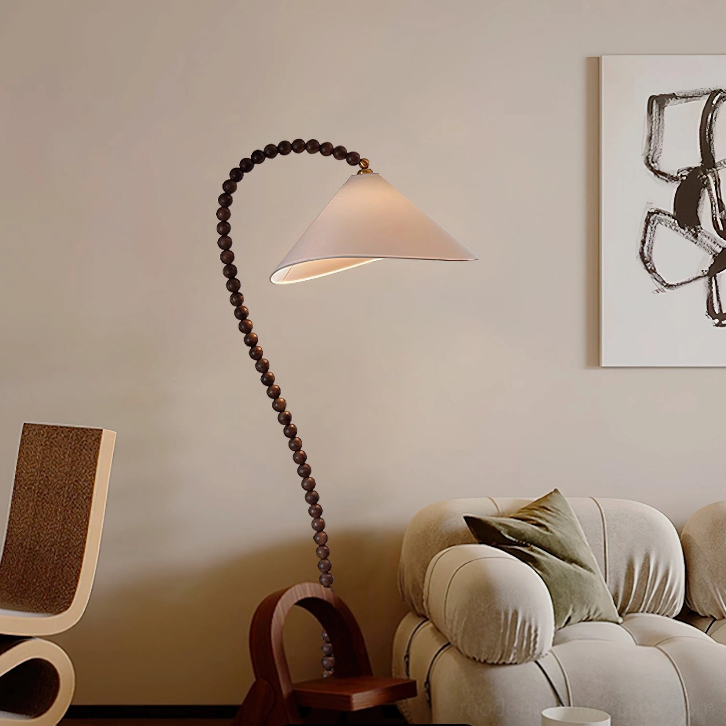 Side angle view of sculptural wooden beaded floor lamp near beige fabric sofa