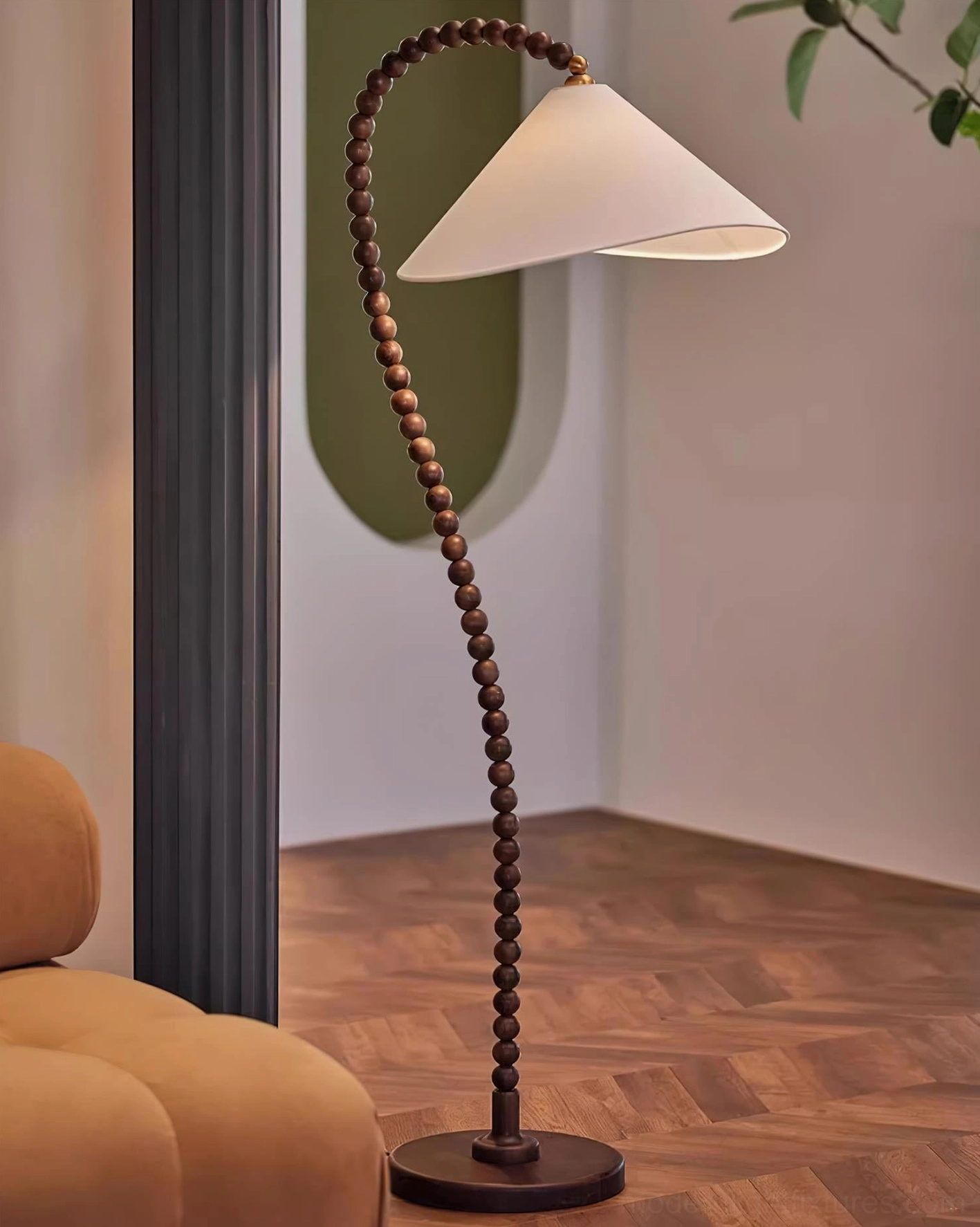 Modern wooden bead floor lamp in minimalist living room corner with tan sofa and wood flooring