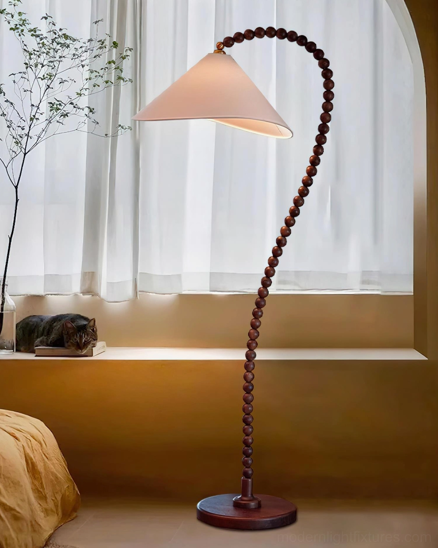 Sculptural wooden bead floor lamp in bedroom corner with yellow window seat and natural light
