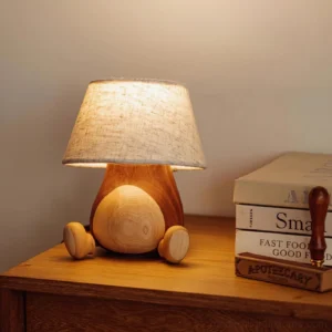 Cute wooden table lamp creating warm ambient glow on wooden nightstand with stacked books