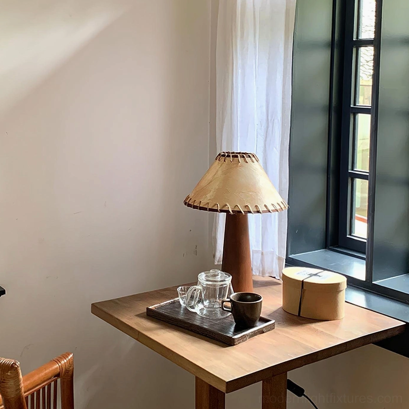 Wooden base lamp with hand-stitched jute shade on side table near window, ambient vintage interior showcase