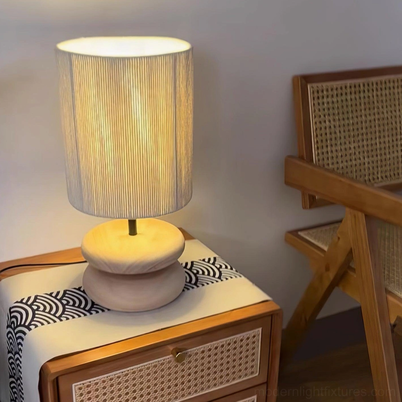 Wooden lamp with natural grain patterns on stacked base and pleated fabric shade