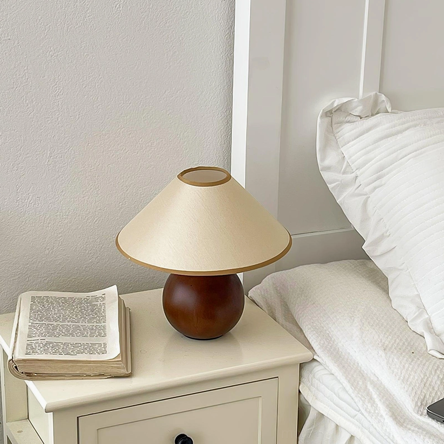 Wooden table lamp placed in home reading corner with books and accessories, functional lighting