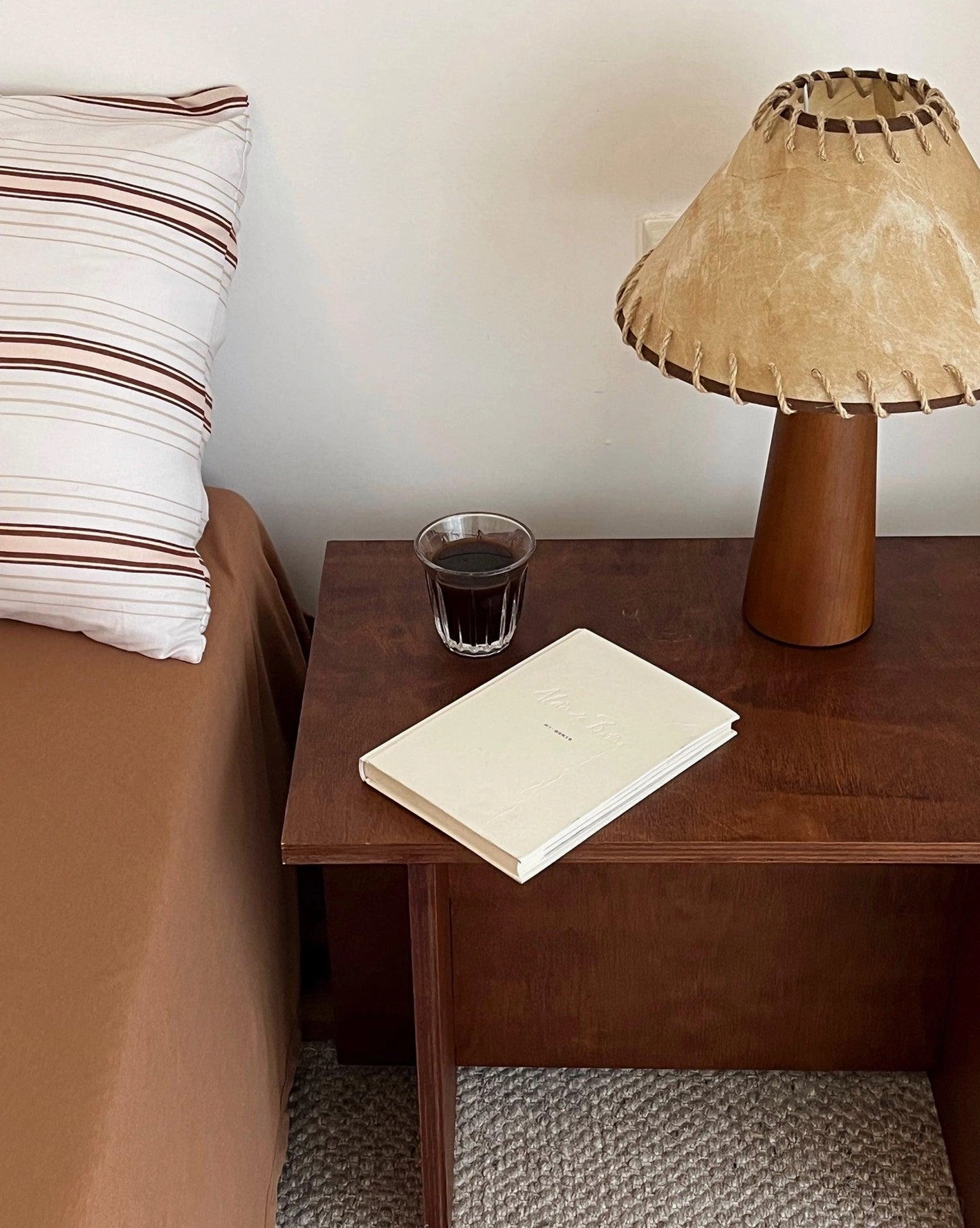 Wooden base lamp with textured jute shade showing warm color temperature and soft light diffusion quality