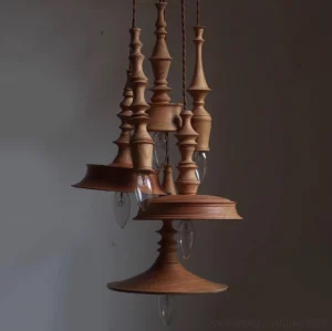 Set of stacked vintage turned wood pendant lights with exposed candle bulbs, minimalist design
