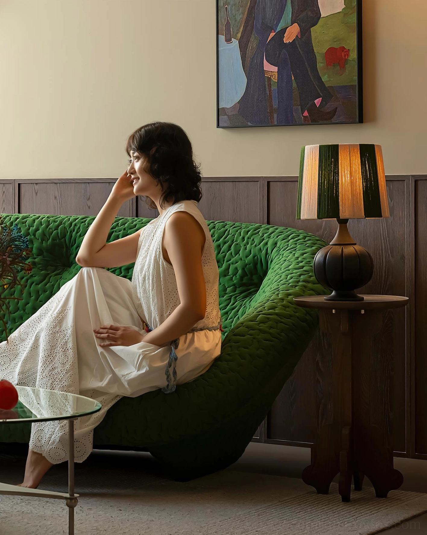 Brown striped wooden table lamp on wooden side table in luxury living room with green velvet sofa
