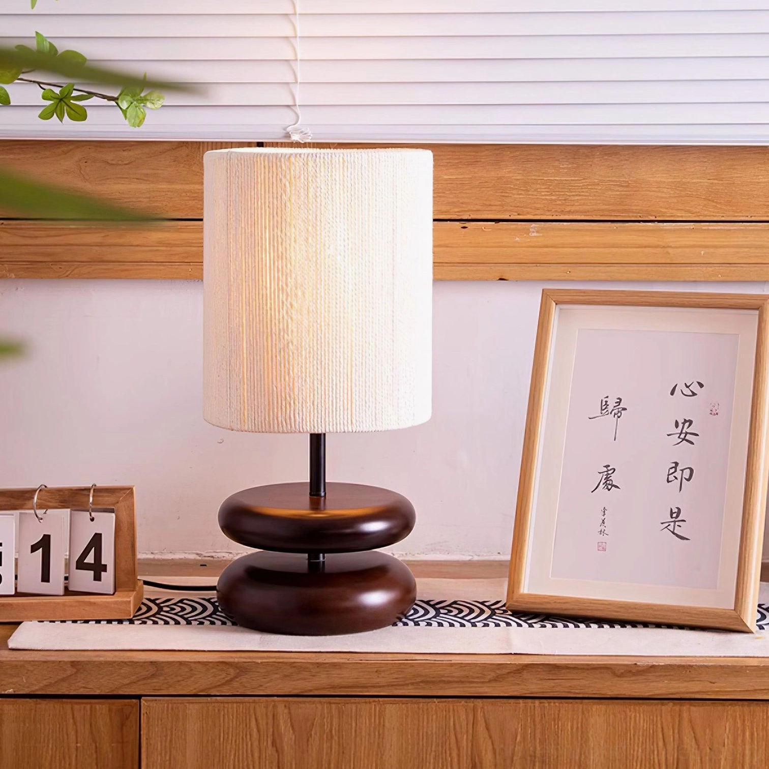 Modern wood stacked base lamp with fabric shade positioned on console table in home setting